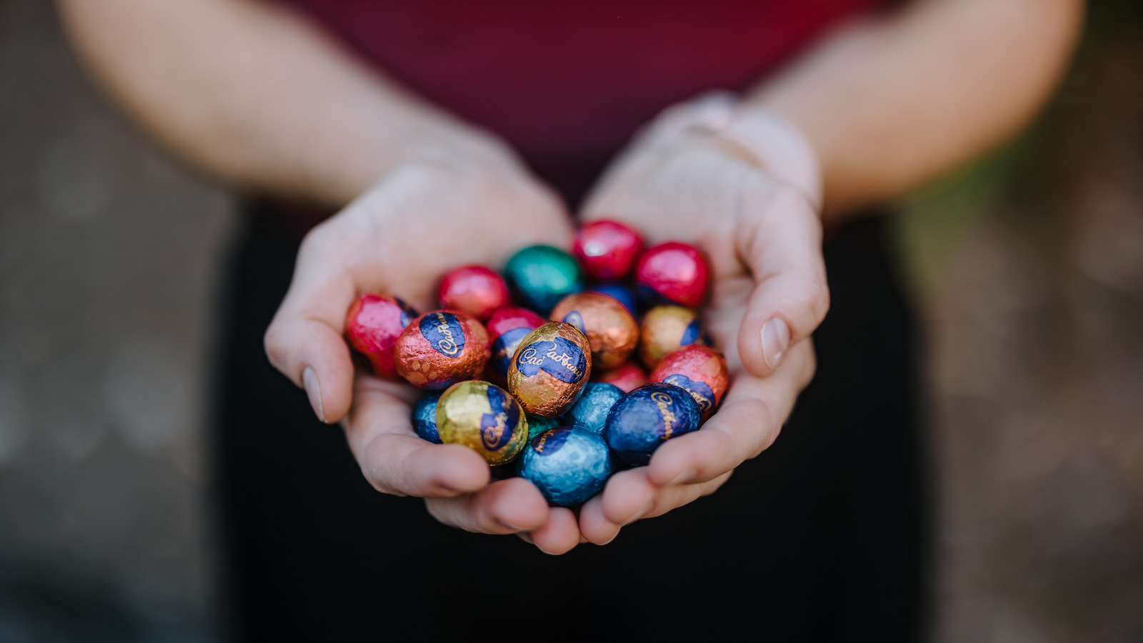 Steph holds a handful of chocolate Easter eggs in her outstretched hands. Photo: Michael Gray